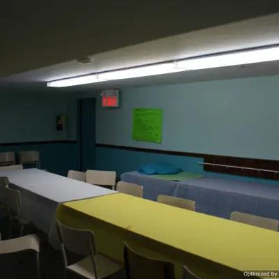 A dimly lit room, with multiple table and chairs setup.