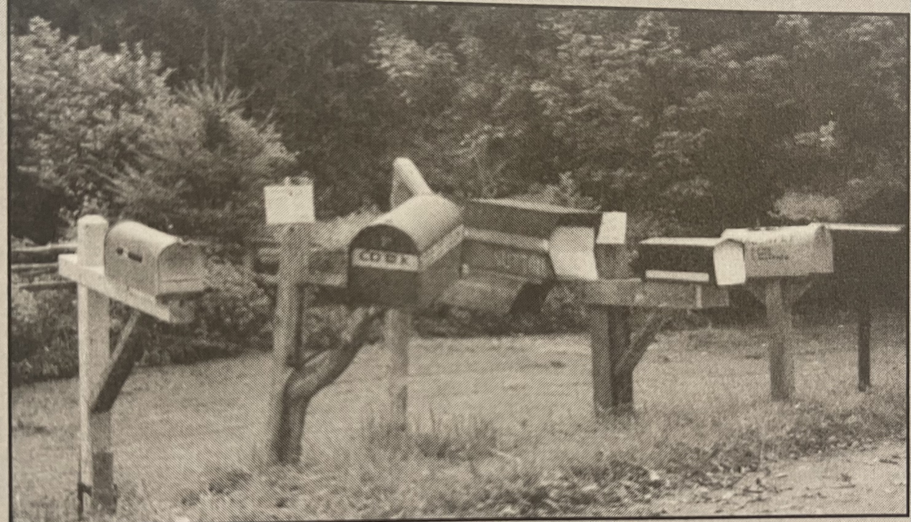 An old photograph of mailboxes lining the side of a road.