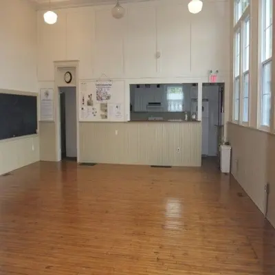 Interior view of a mid-century building, with shiny wooden flooring.